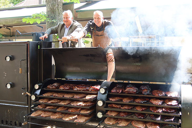 Menterschwaige Wirt Christian Schottenhameel und Josh Jabs am 1,7 t schweren schweren XXL Smoker im Biergarten des Gutshof Menterschwaige (&copy;Foto: Martin Schmitz)
